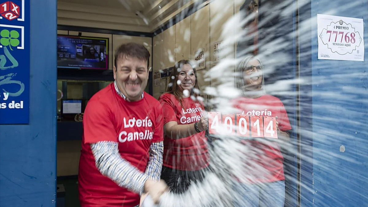 El propietario de una administración de lotería celebrando haber repartido el segundo premio. EFE